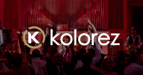 Hudobná skupina KOLOREZ band vystupuje na pódiu pred tancujúcim publikom v sále s organom v pozadí.