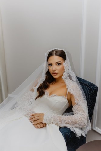 Elegantný portrét nevesty v čipkovaných svadobných šatách so závojom od profesionálnej fotografky