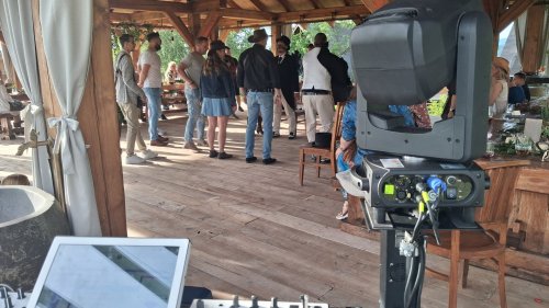 Hostia sa zabávajú na svadbe v drevenom altánku s pohľadom z perspektívy DJ stanovišťa s profesionálnou technikou.
