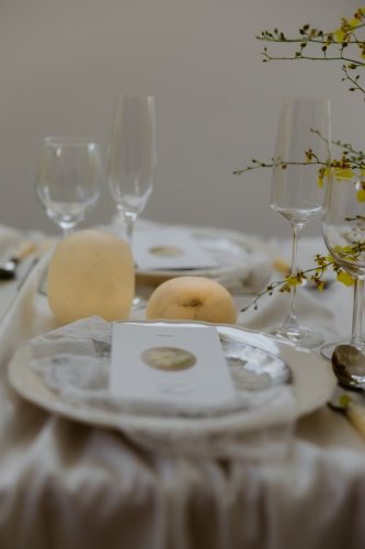 Elegantne prestretý svadobný stôl s bielym menu lístkom, jemným textilom a žltými kvetmi zachytený v rámci série Pár Vašich momentov.