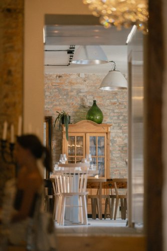 Štýlový interiér reštaurácie Truffle pig Trnava s odhalenou tehlovou stenou, dreveným nábytkom a elegantným prestieraním.